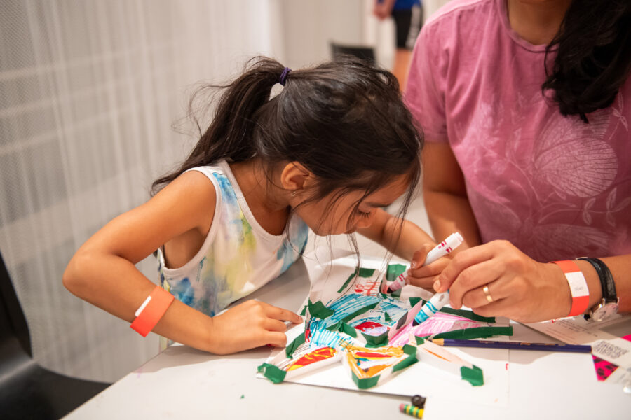 child focused on an art project with colorful markers
