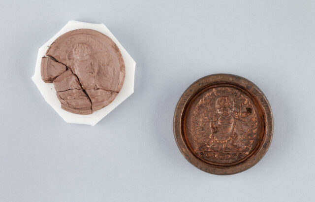 Two halves of clay and copper mold used to produce votive tablet depicting wrathful deity