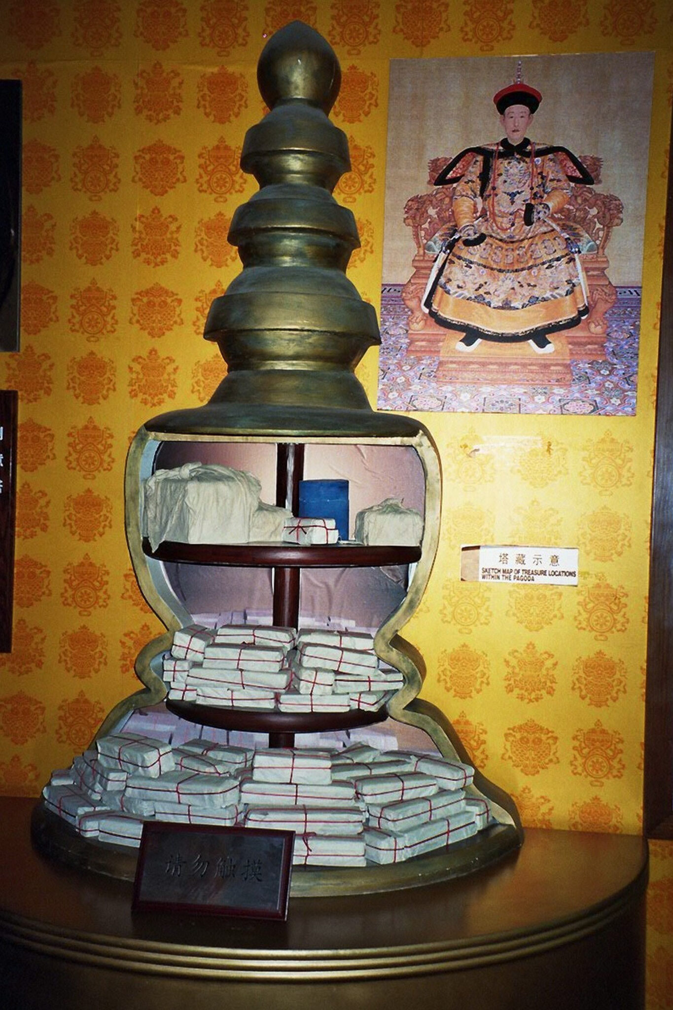 Model of architectural ornament with cutaway revealing packages wrapped in beige material and red string