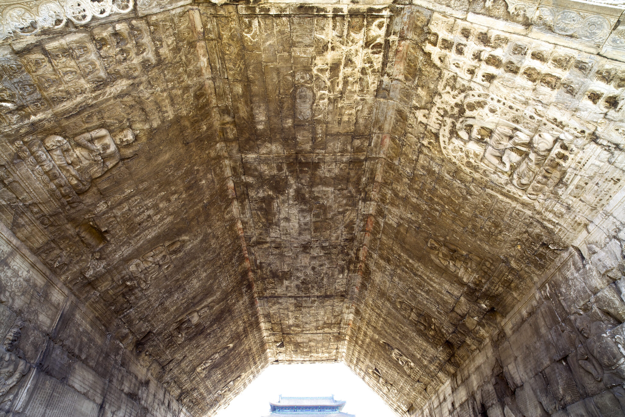 View from below of vaulted, three-paneled ceiling bearing reliefs featuring multitude of scenes and figures