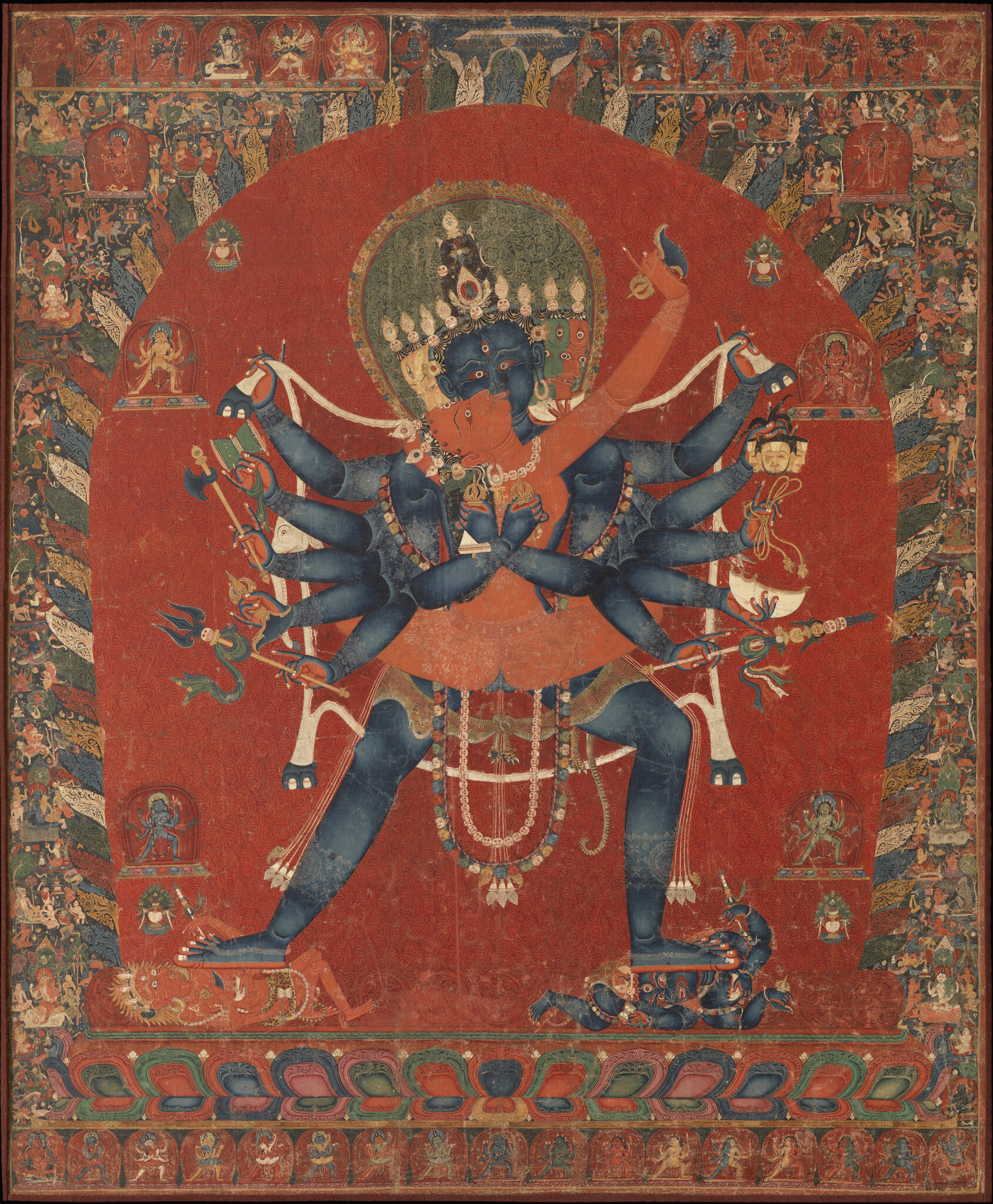 Many-armed, blue-skinned deity locked in embrace with orange-skinned deity holds animal pelt behind back