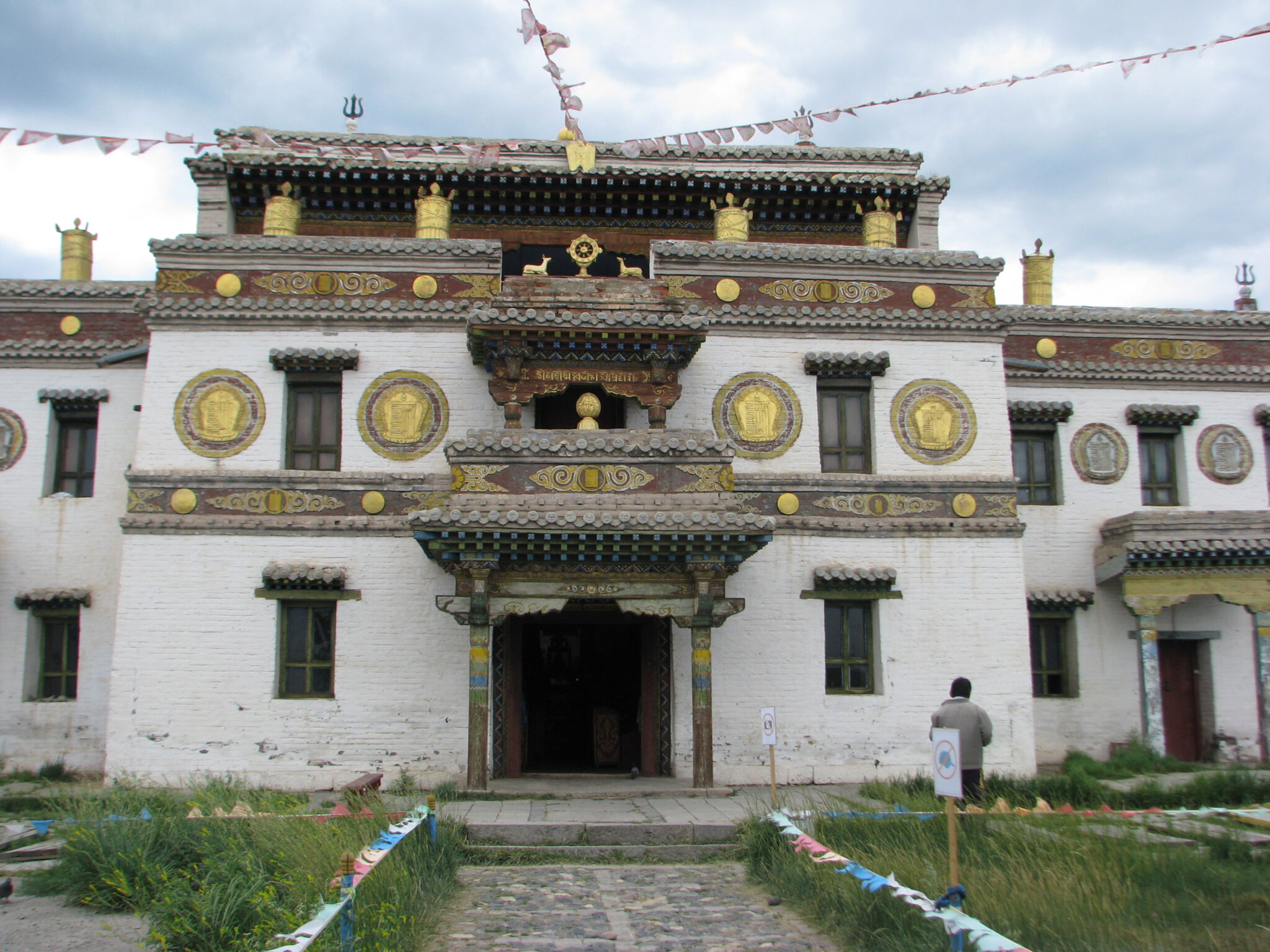 Photograph of three-story building decorated with patterned bands and golden roundels on first floor