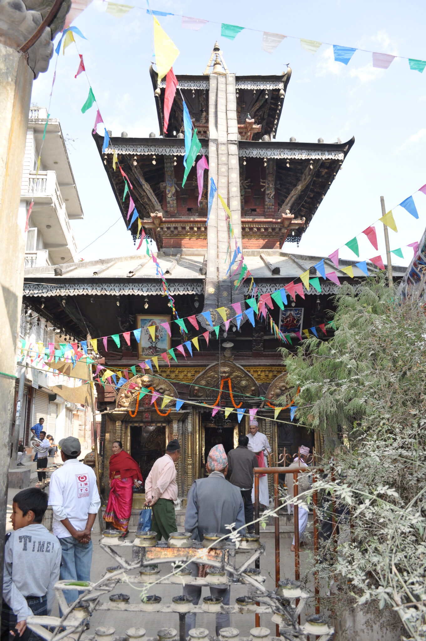 View through colorful pennant strings of three-story pagoda with thin banner descending from spire