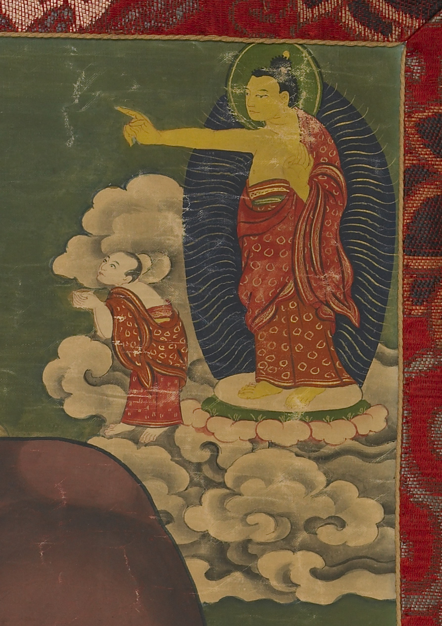 Buddha in red and gold brocade robe extends left arm and points above head of attendant