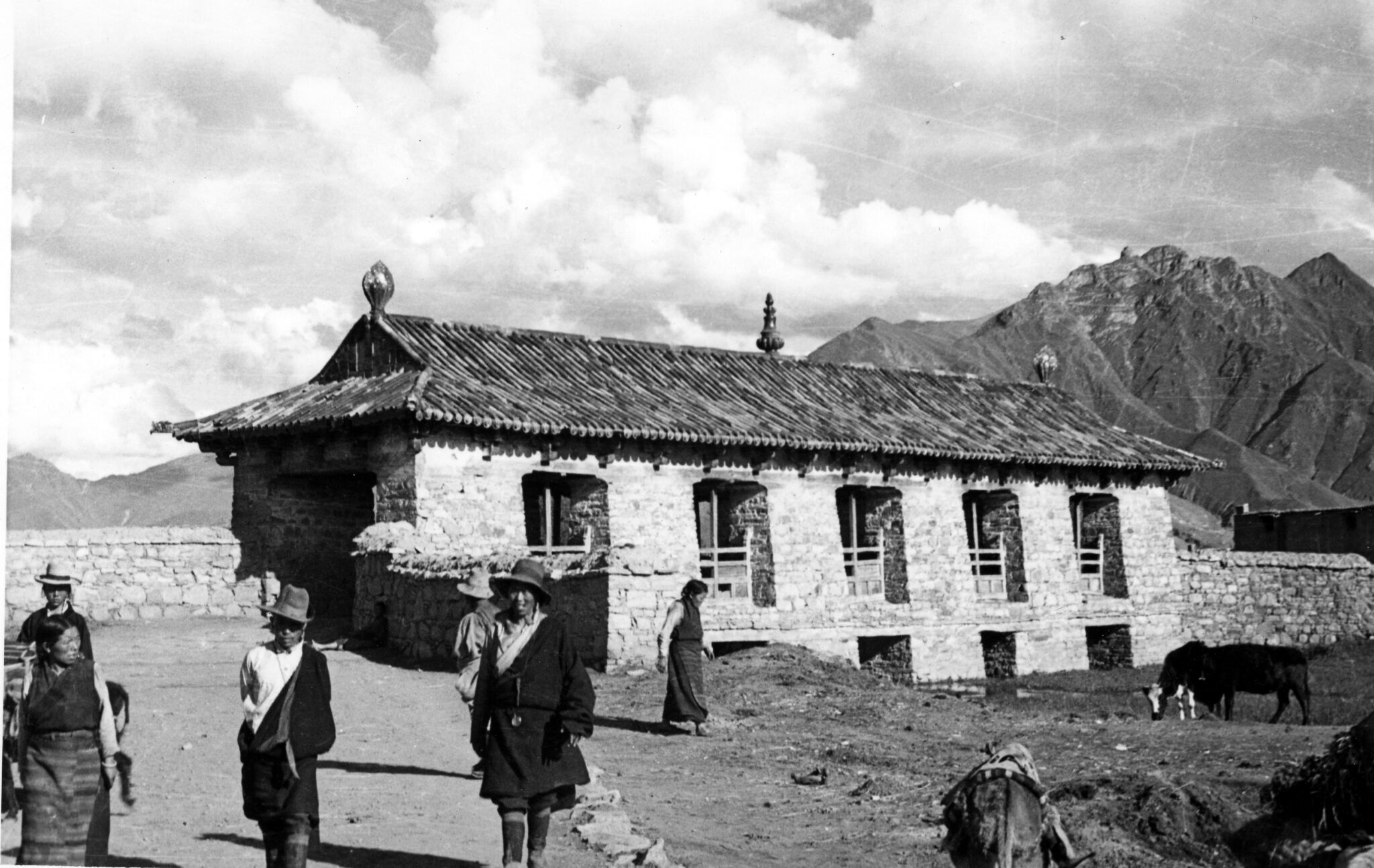 Black and white photograph of covered stone bridge featuring tiled, pitched roof and finials