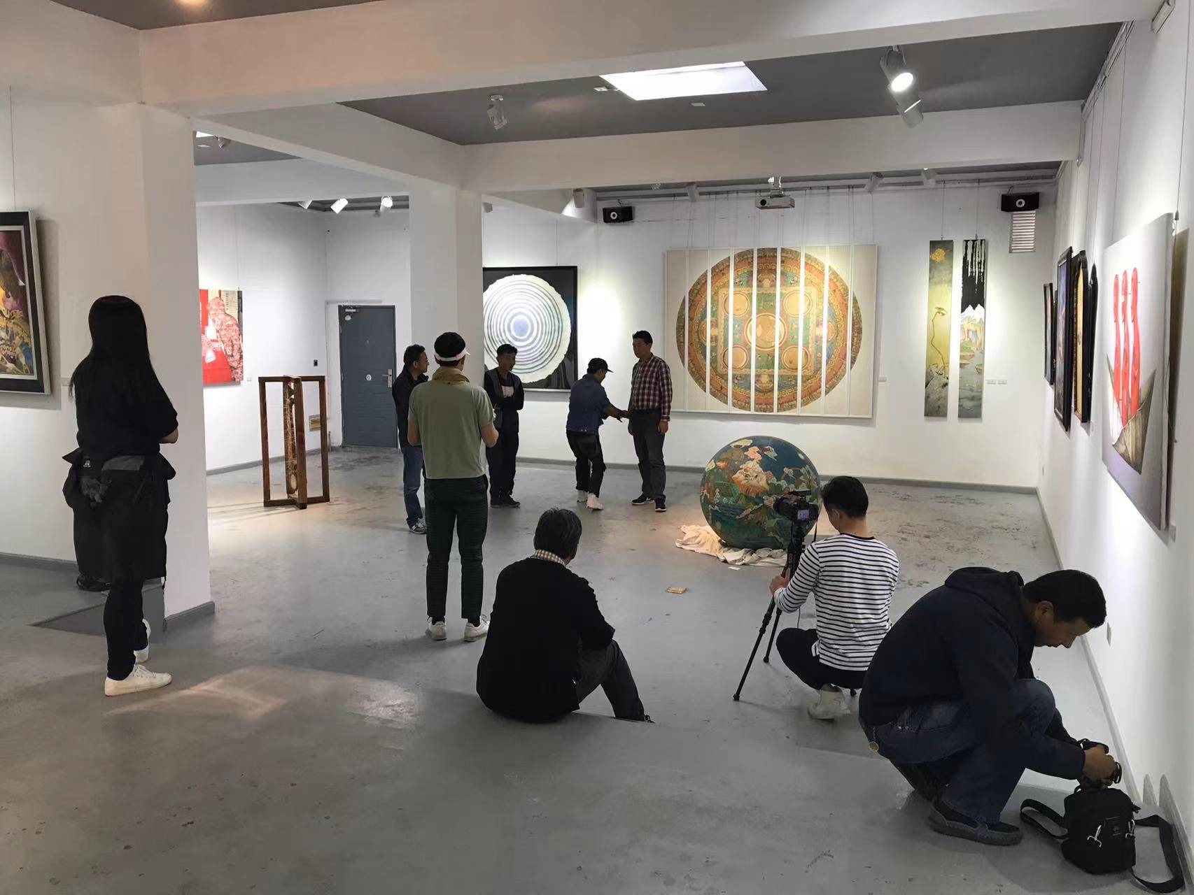 Photograph of visitors photographing contemporary art influenced by classical Tibetan art