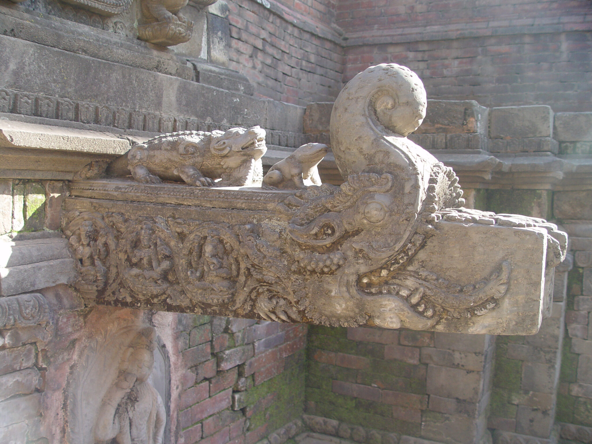 Rectangular stone fountainhead in the form of elephant-like creature with raised trunk and gaping, toothy mouth