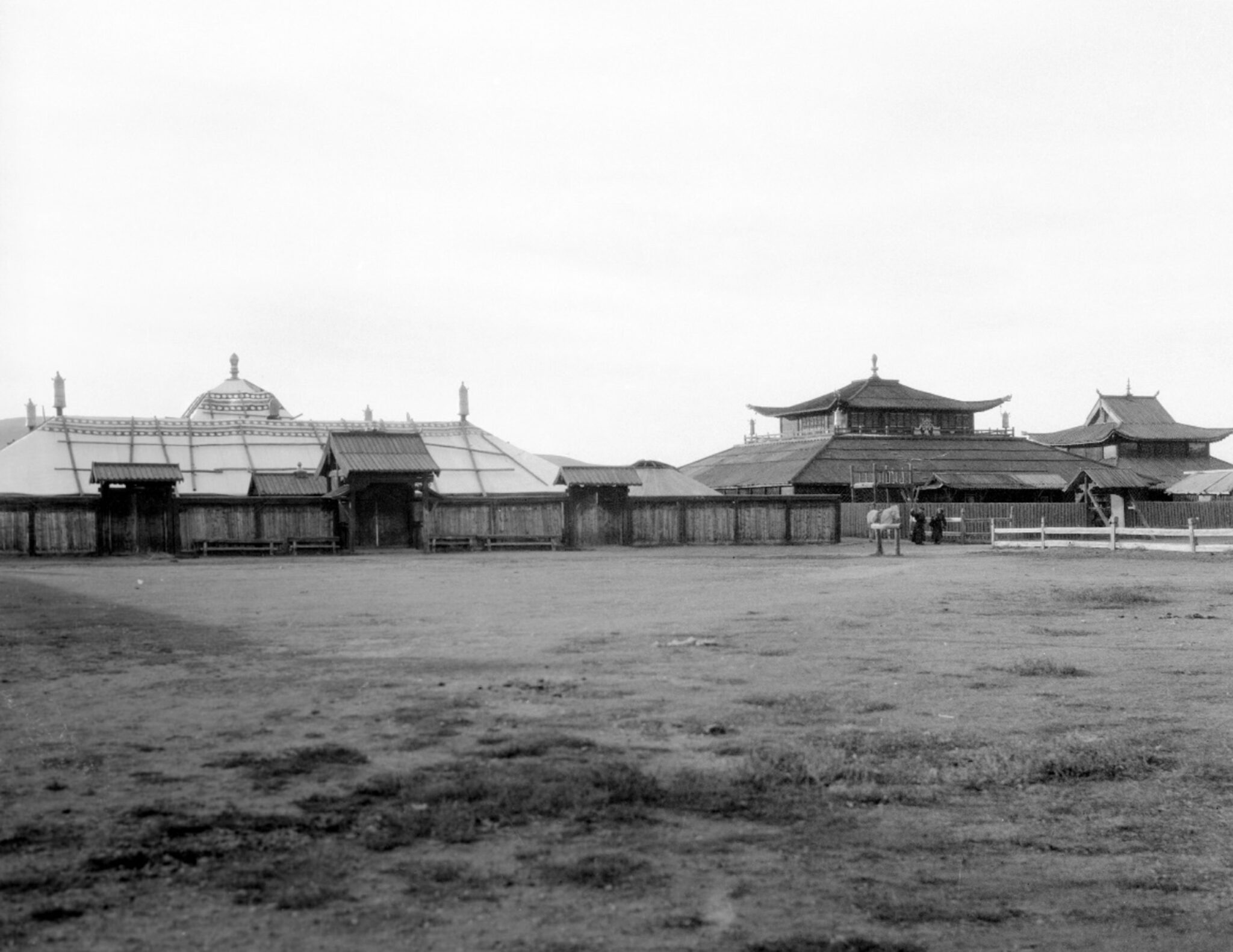 Black and white photograph of architectural complex featuring tent-like structure and two pagoda-roofed buildings