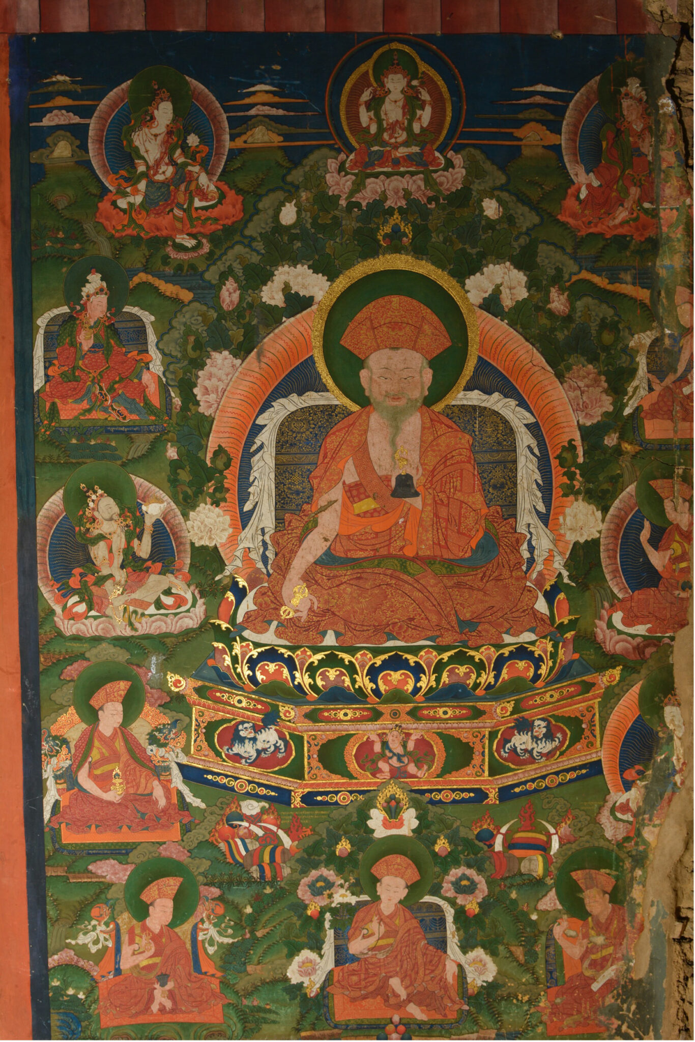 Lama wearing saffron robe enthroned amidst green mountain landscape, surrounded by deity and lama portraits