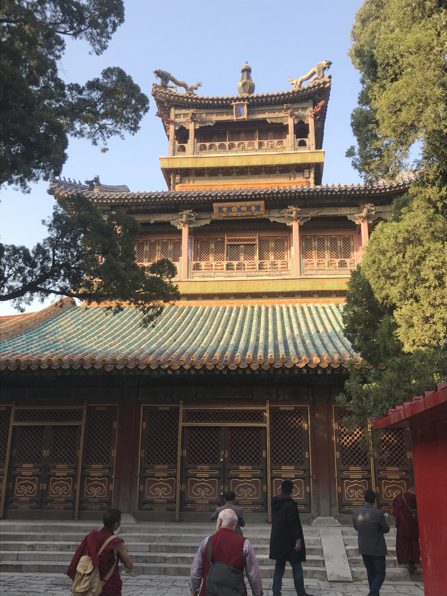 Three-story pagoda-roofed pavilion featuring elaborately carved loggia eaves and intricate window screens