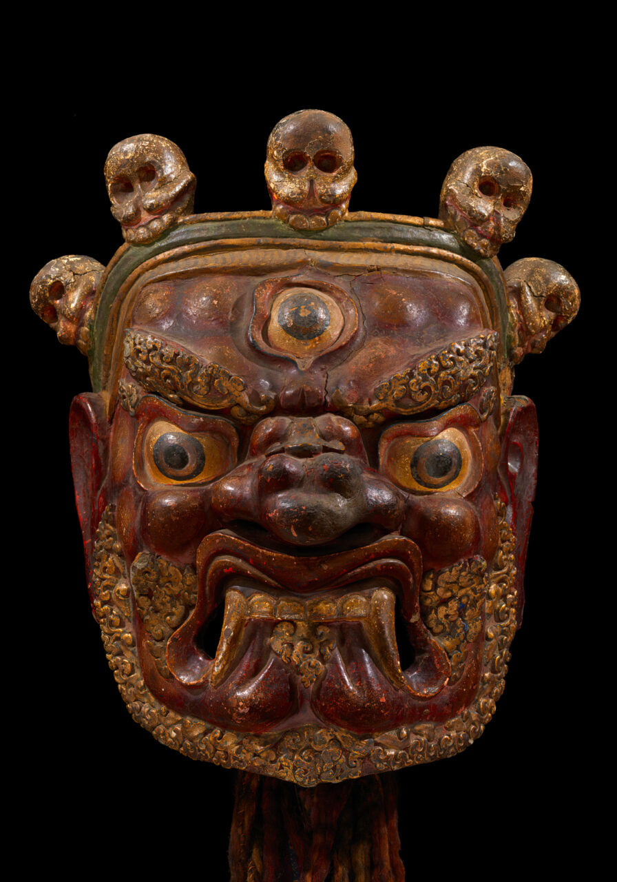 Mask depicting wrathful deity with third eye and bared teeth; features five-skull crown and filigreed beard