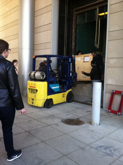 A forklift is used to safely remove crates from the freight elevator.
