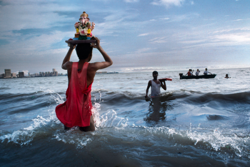 Steve McCurry; Hindu devotee carries statue of Lord Ganesh into the waters of the Arabian Sea during the immersion ritual off Chowpatty Beach; Mumbai, Maharashtra; 1993