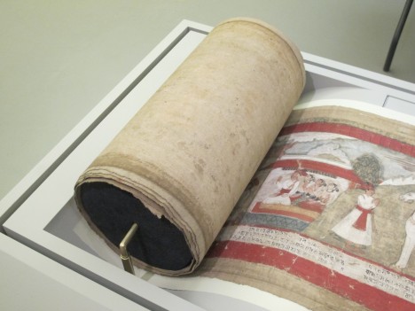The scroll is rolled around an archival tube. A brass mount supports the piece so it does not put pressure on the bottom of the scroll.