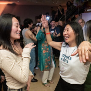 Two people dancing freely and smiling at the Rubin Museum.