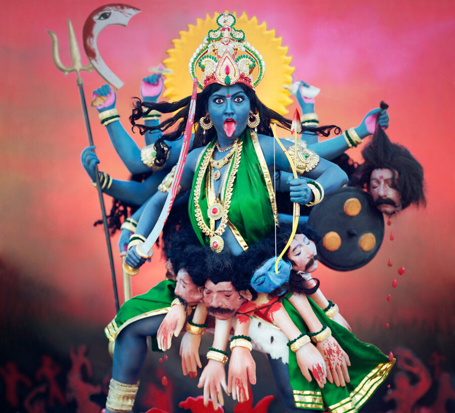 Bold, dramatic statue or tableau of the Hindu goddess Kali in a dynamic pose.