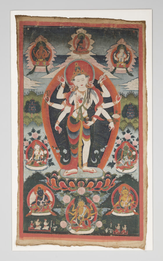 Thangka painting of a standing multi-armed deity with a crown and orange aureole, poised on a lotus base, surrounded by six smaller seated deities in framed roundels and a green landscape background.