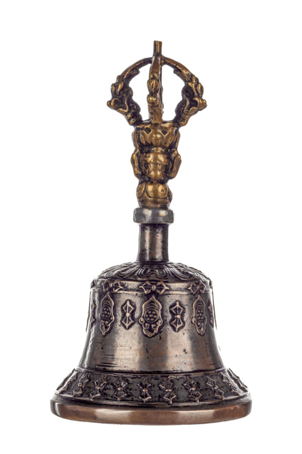 Metal bell with detailed engravings. The handle has a human head below a double-ended, symmetrical structure resembling four crescent moons that meet at the top.