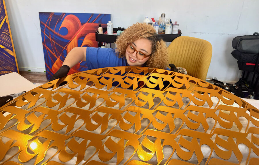 sneha shrestha holding the top of a gold sculpture