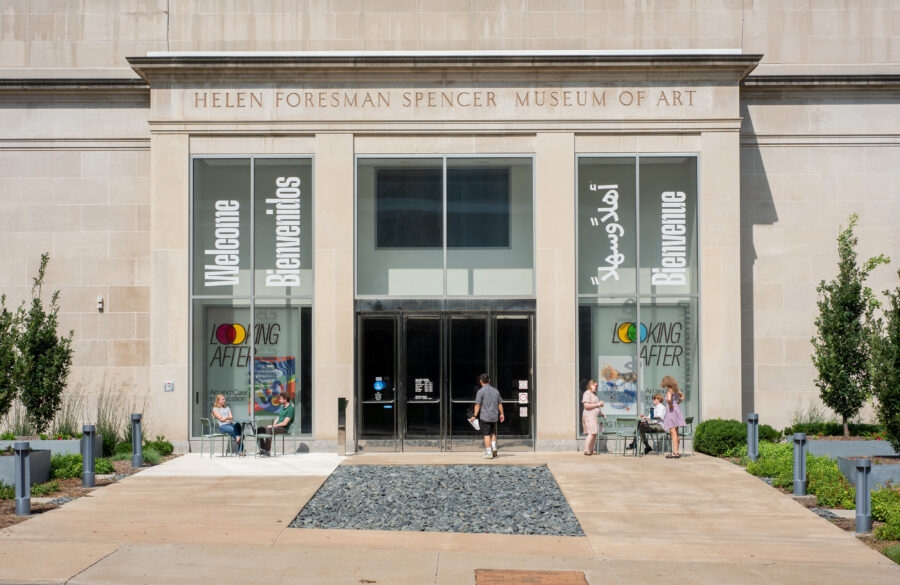 A beige building with the words "HELEN FORESMAN SPENCER MUSEUM OF ART" above glass doors and windows