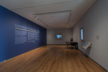 A photograph of an exhibition hall with wall text at the McMullen Museum of Art.