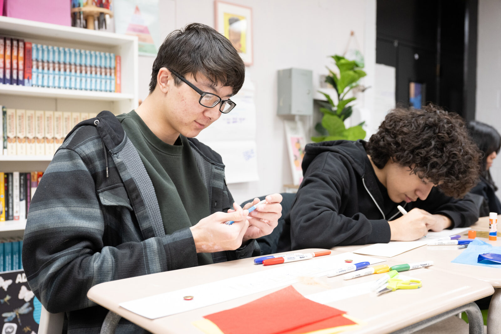 two students in the classroom working with art supplies