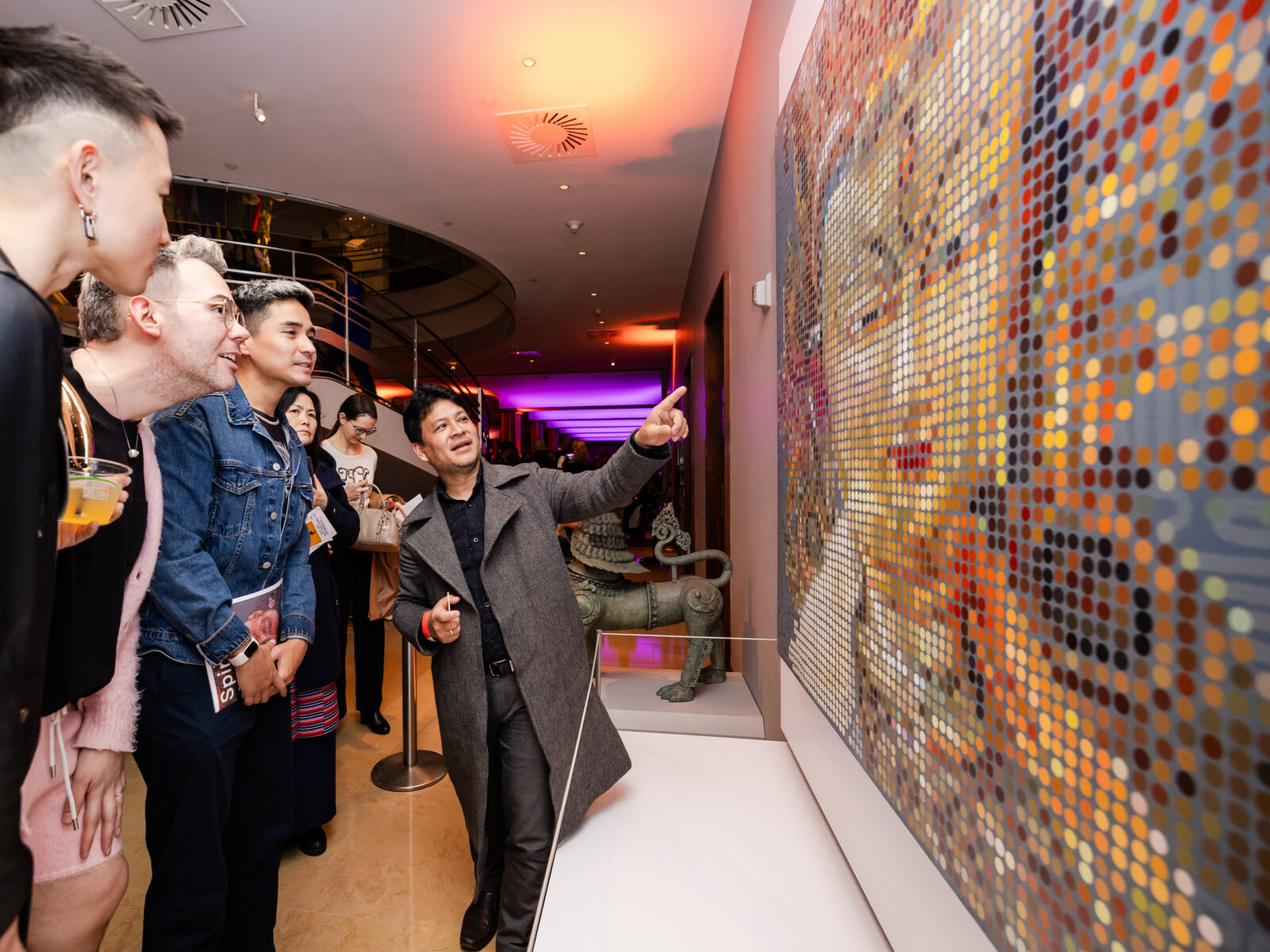 a group of adults looking at an artwork mounted on a wall