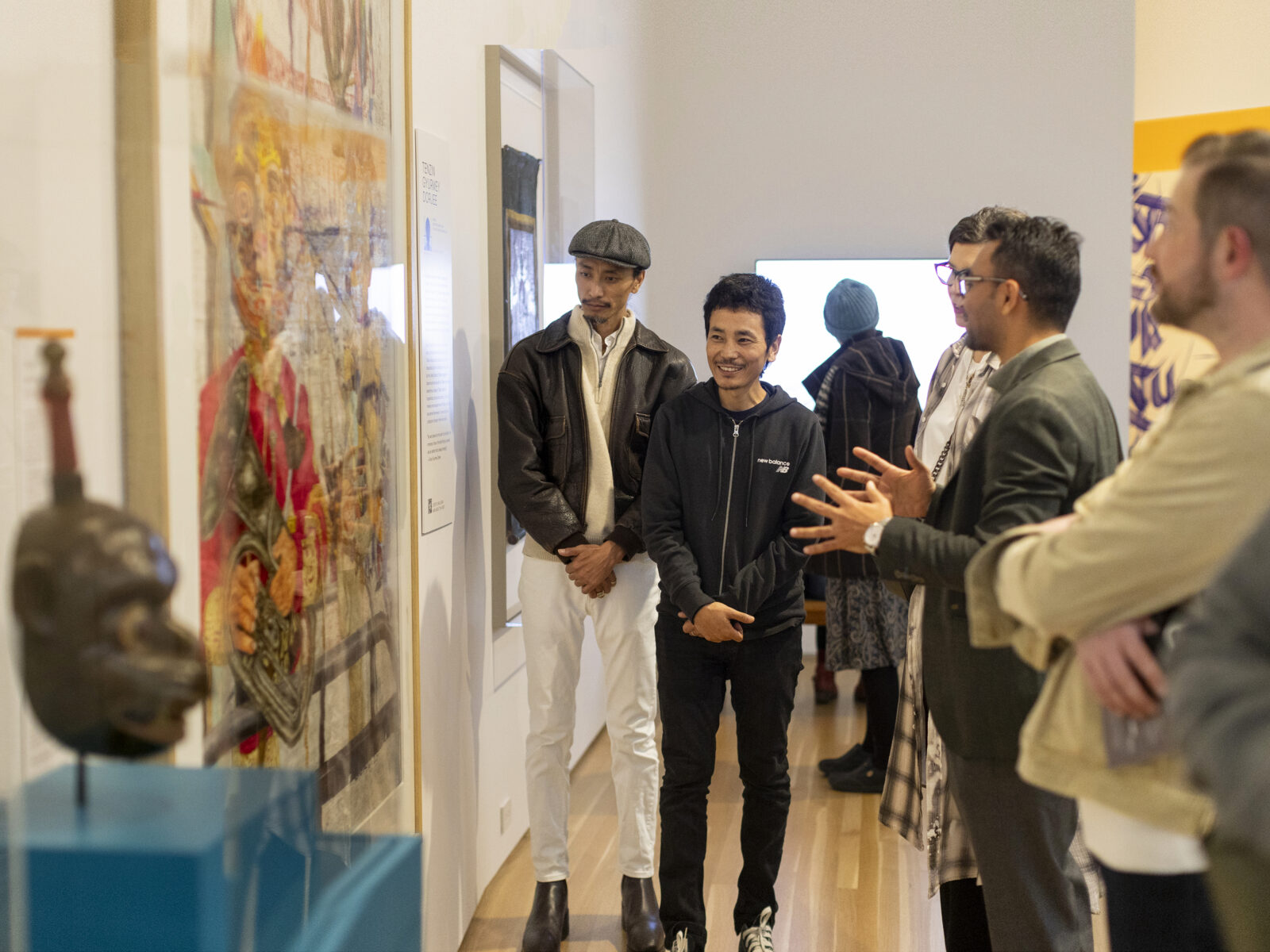 two adults looking at a framed artwork on a gallery wall