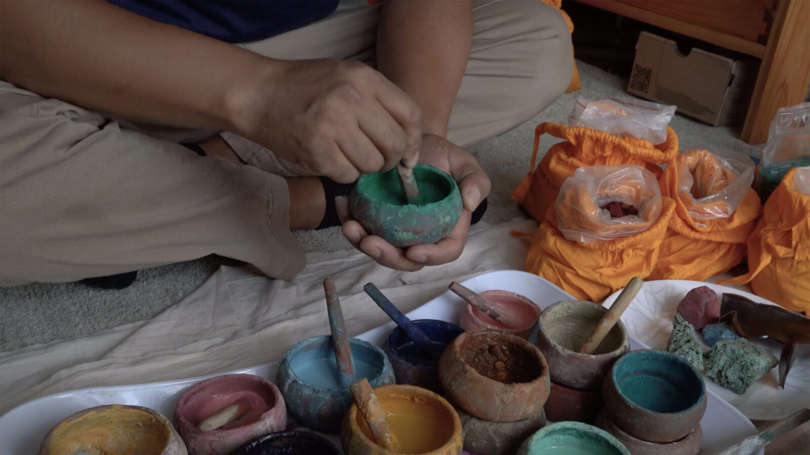 Close-up of hands mixing paint colors.