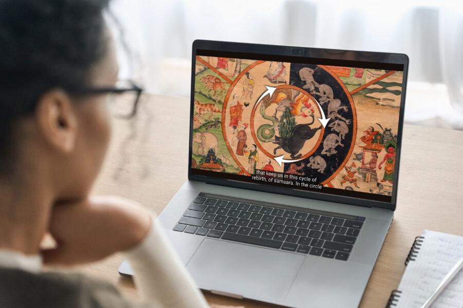 Person looking at a computer screen and watching a Himalayan Art Up Close video about the Wheel of Life