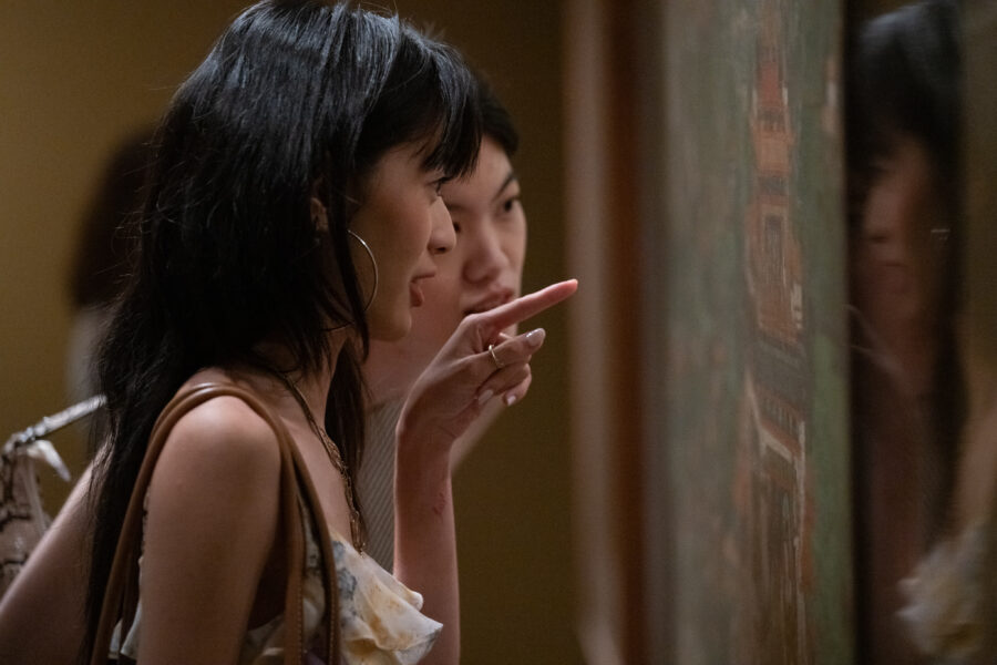 two people close looking at a painting in a gallery