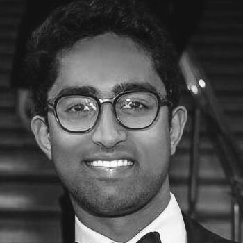 black and white photo of a smiling man wearing glasses