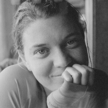 A close-up, black-and-white portrait of Maggie Doyne filling the frame.
