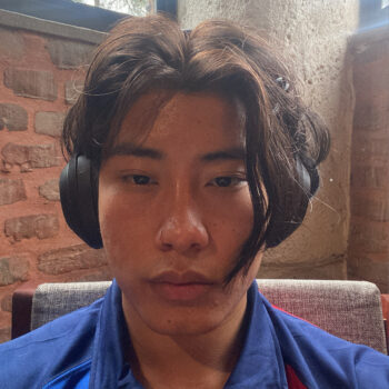 an adult man with a nose piercing wearing black headphones