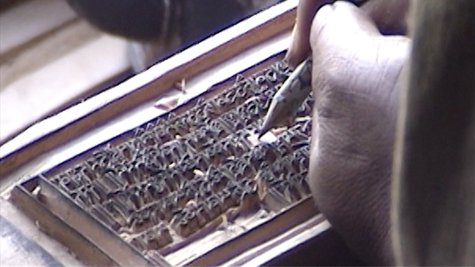 a person is carving a woodblock with a tool
