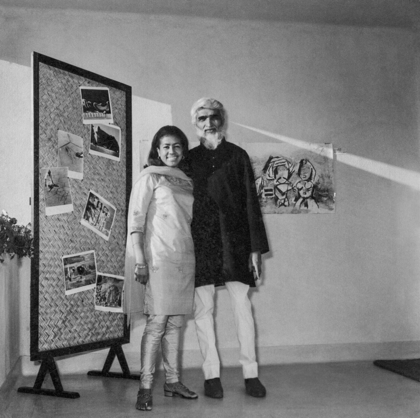 black and white photo of sister max smiling and standing arm and arm with m.f. husain