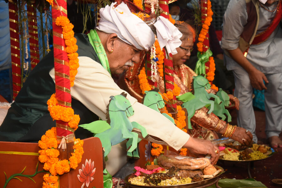two elders participating in the bhimaratha ritual in carriages adorned with orange flowers