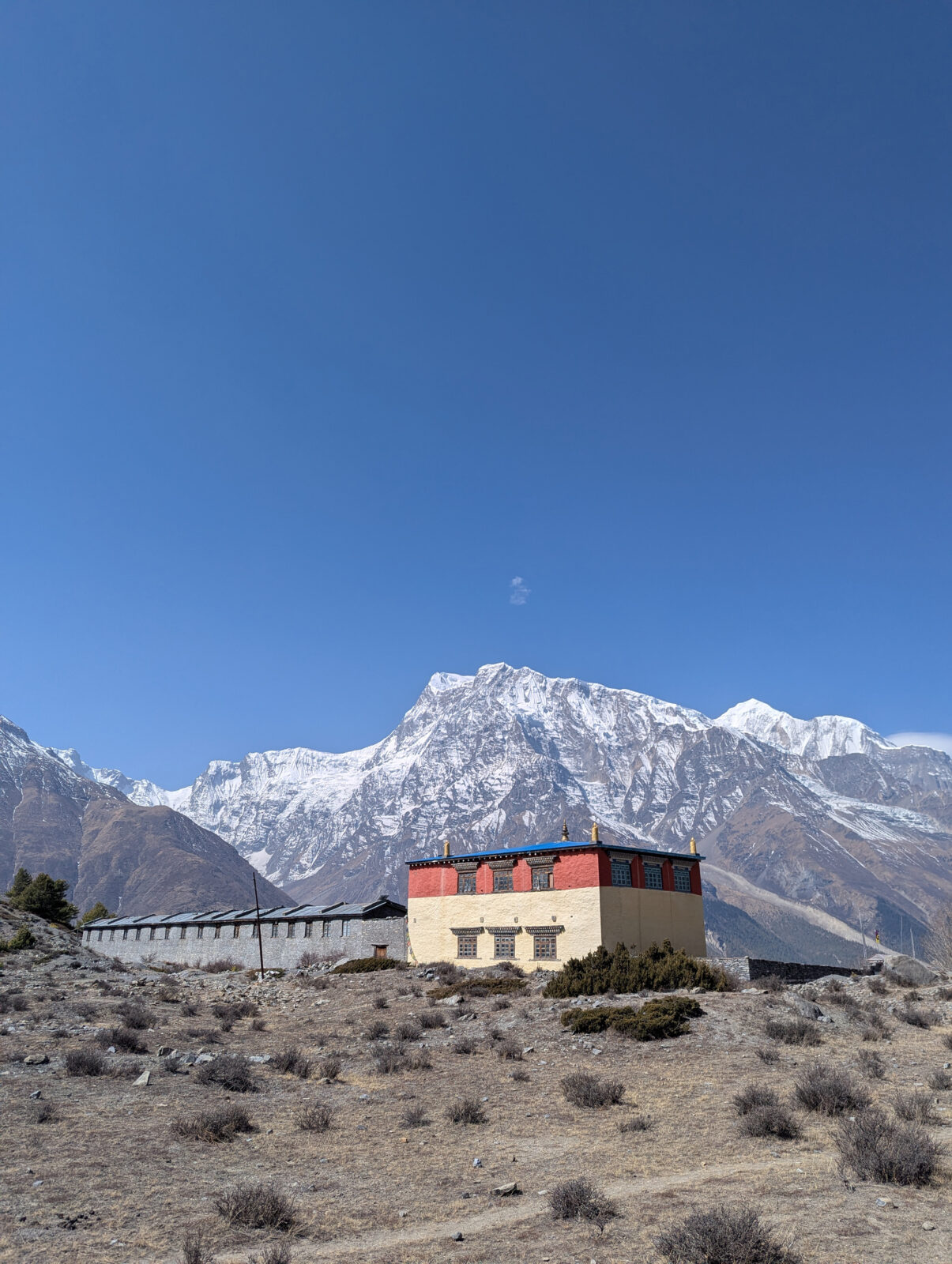 mountain range in background with a square monastery in the forefront