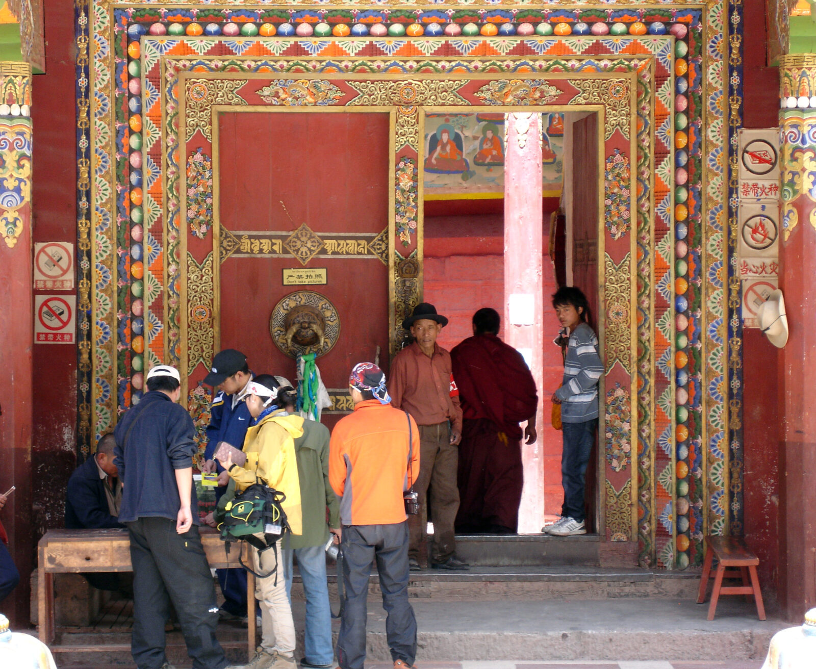 group of people standing in front of a large door with a painted door frame