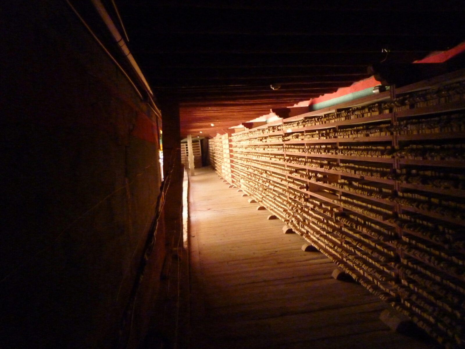 hallway with bookshelves along one side, filled with many woodblocks