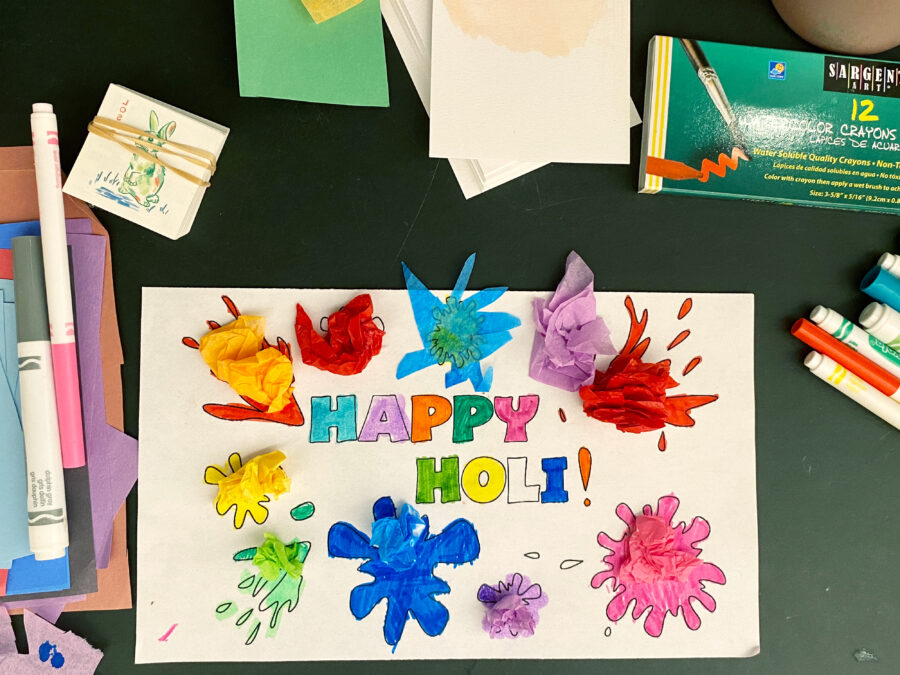 A colorful, handmade sign reading "Happy Holi"