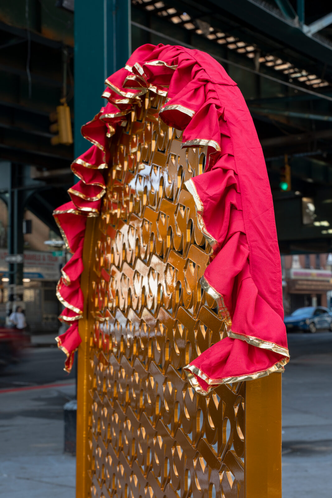Close up of IMAGINE's (a.k.a. Sneha Shrestha) sculpture, About a Living Culture, focusing on the red fabric at the top of the golden arch