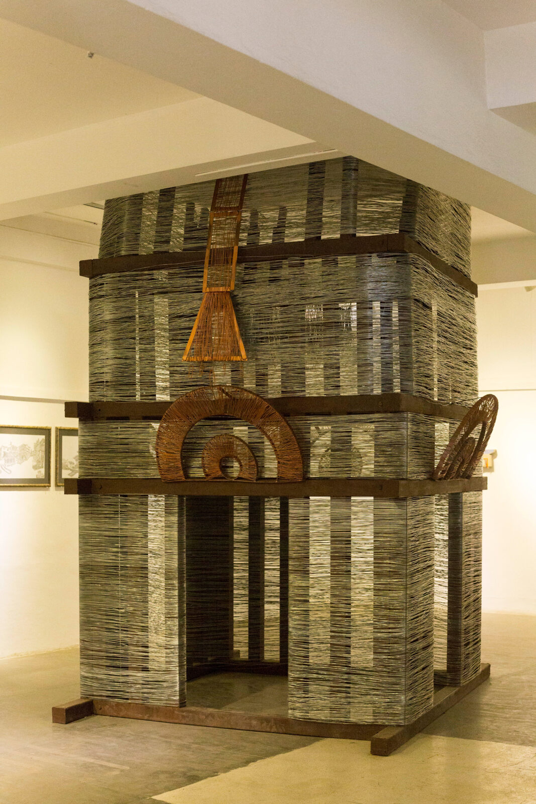 wire and rod sculpture extending from floor to ceiling with decorative features