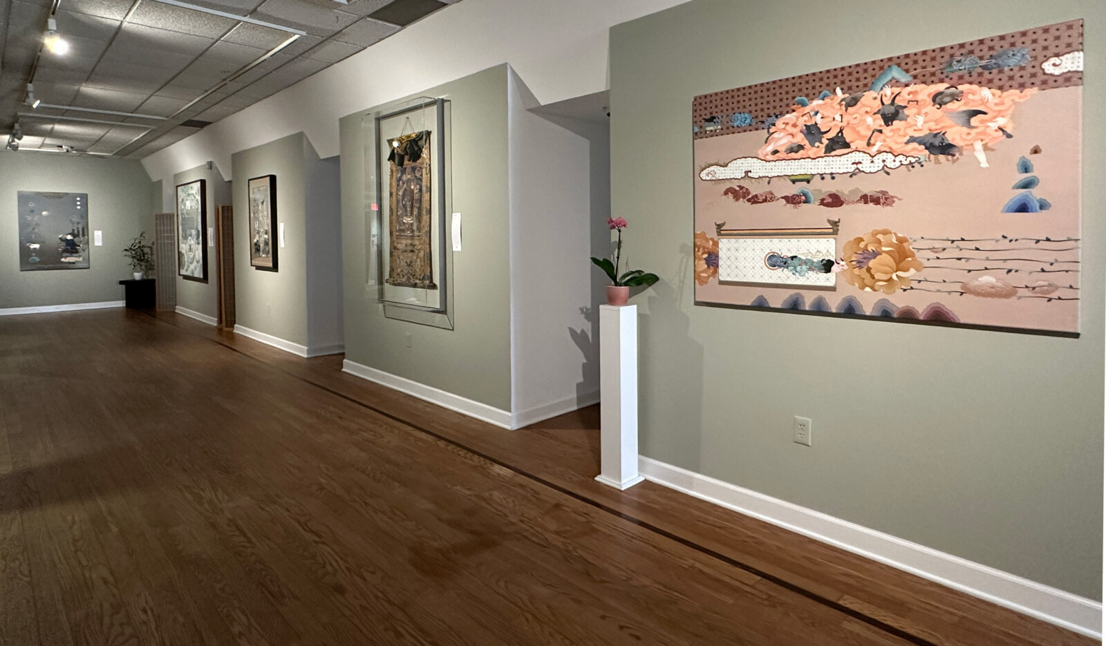 room of paintings hung on light green walls, Uuriintuya Dagvasambuu's