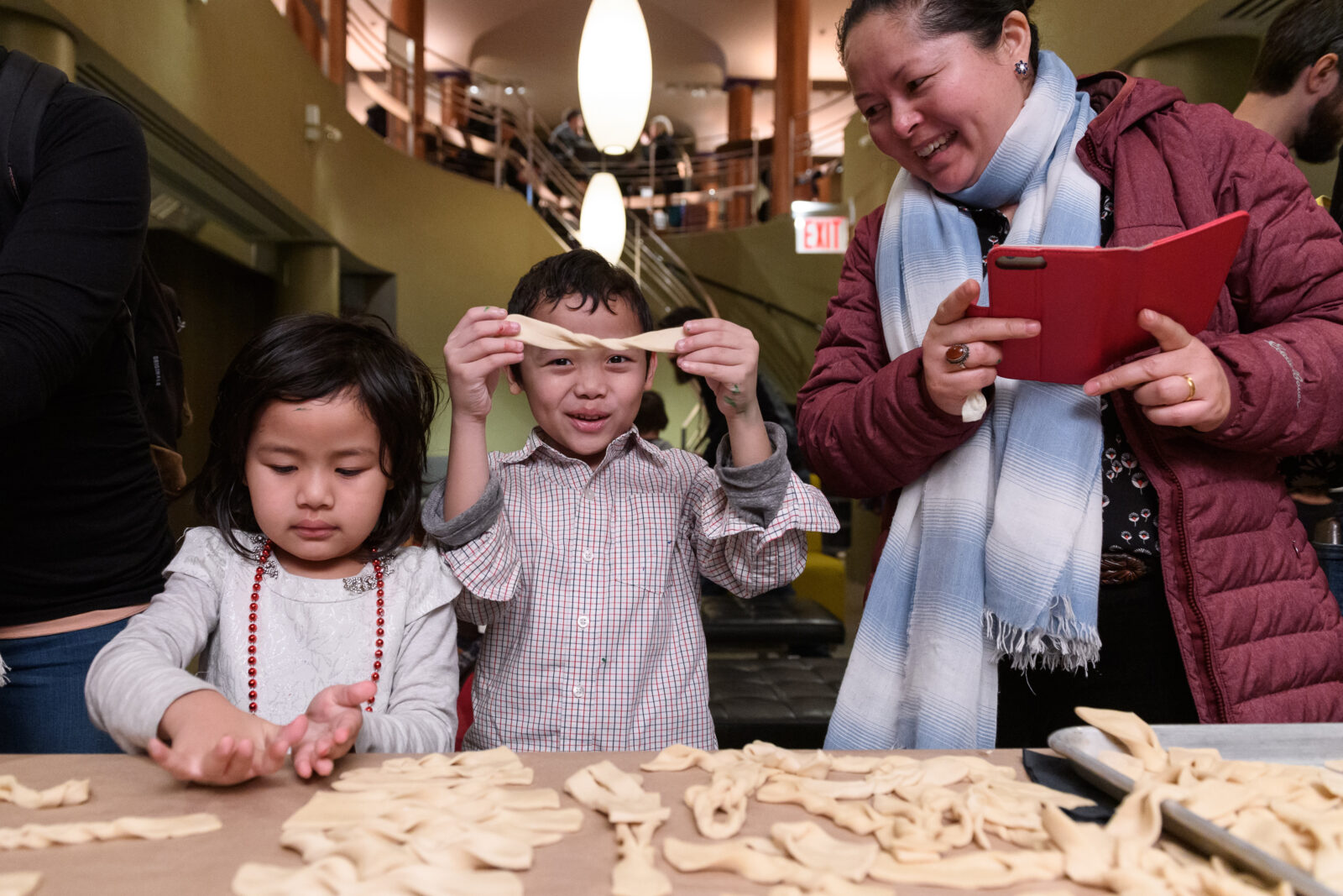 two children rolling out khapse pastry dough