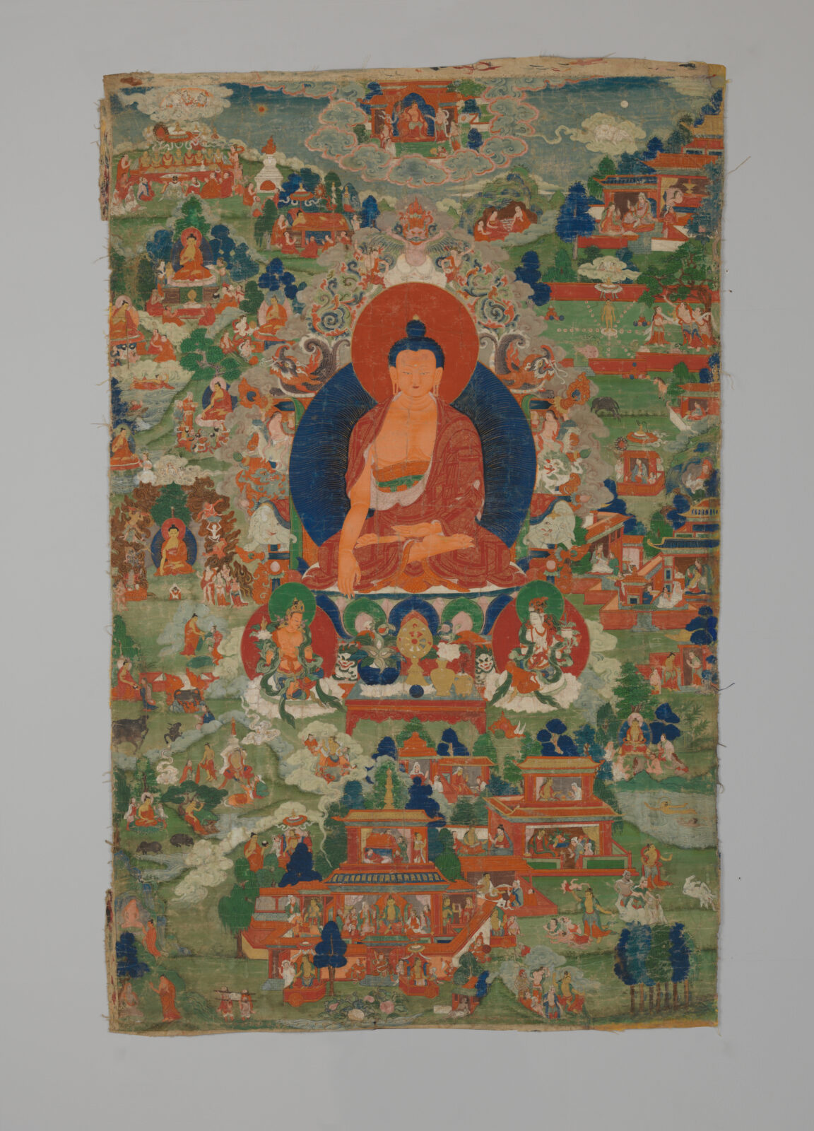 Painting of seated figure on lotus blossom surrounded by smaller figures.