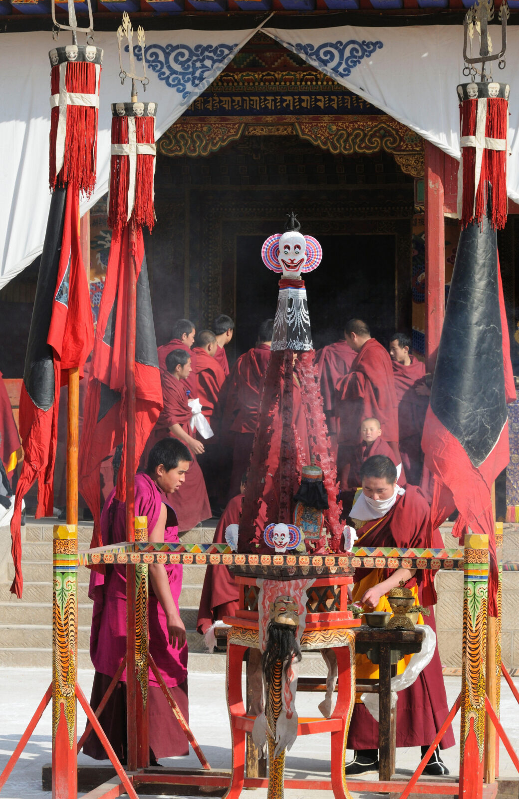 monks in red robes prepare a zortor, a weapon torma
