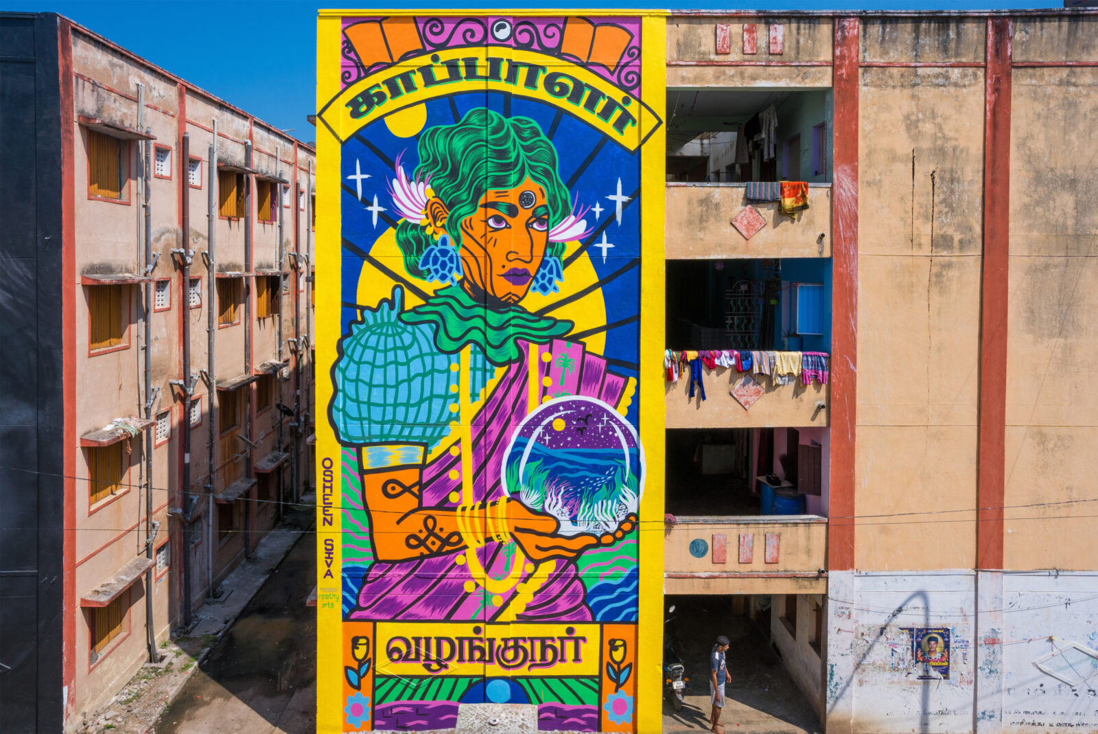colorful mural on the side of an city building by osheen siva