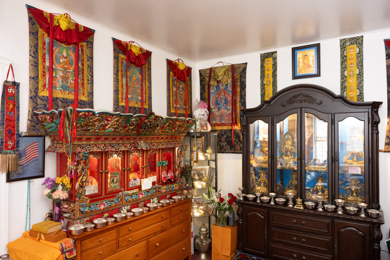 two cabinets and colorful thangkas in a personal household shrine room