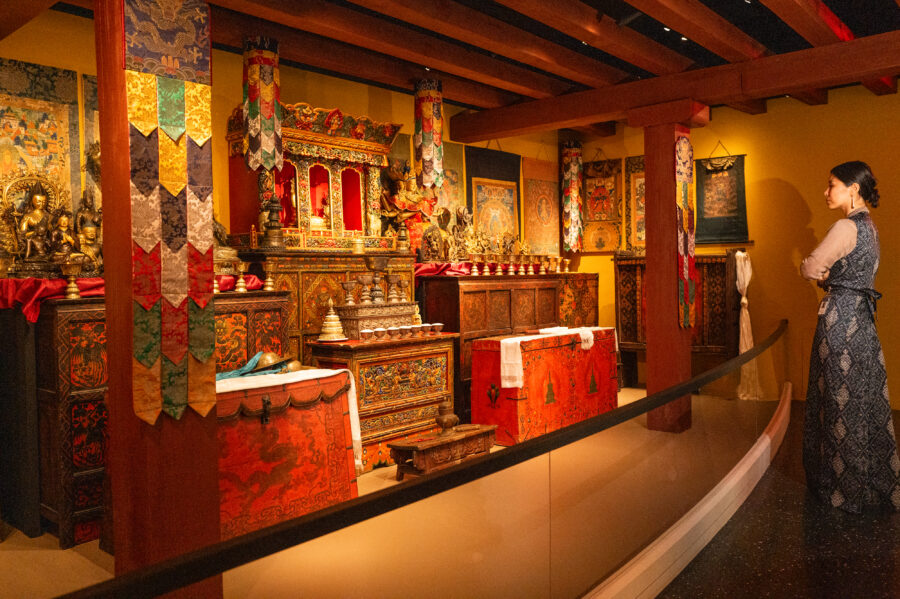 rubin museum tibetan buddhist shrine room installation with visitor onlooking